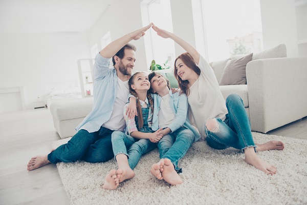 Versicherungscheck Familie spielt Haus