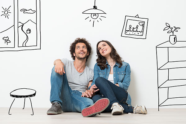 Homestaging Porträt eines glücklichen jungen Paares, das in einer gezeichneten Wohnung auf dem Boden sitzt und nach oben schaut.