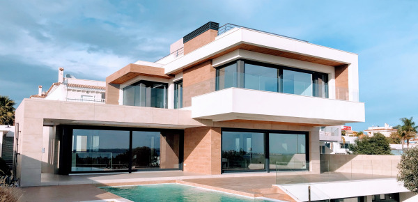 Wertgutachten Modernes Haus mit Aussenschwimmbad bei Sonnenschein.