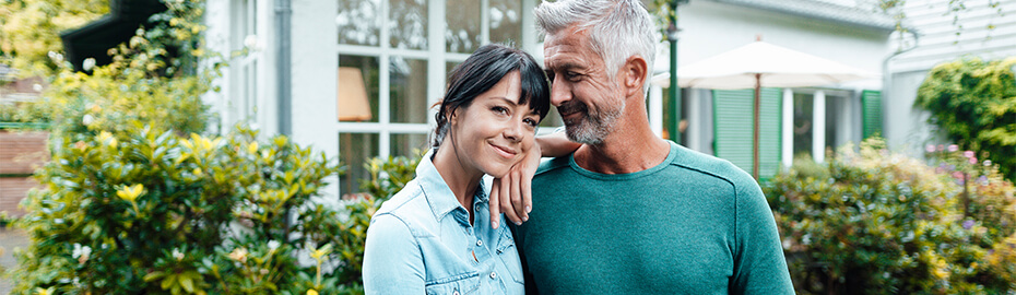 Mann und Frau stehen bei einander im Garten.