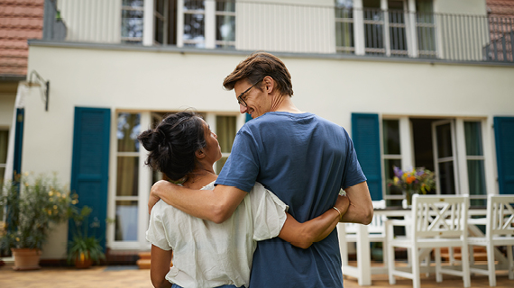 Brakle startbild  Happy real estate agent shaking hands with potential new home buyers.