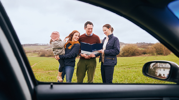 Brakle startbild  Happy real estate agent shaking hands with potential new home buyers.