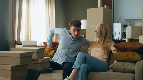 Brakle startbild New homeowners sitting couch at purchased house. Family rent buy
                                        new apartment